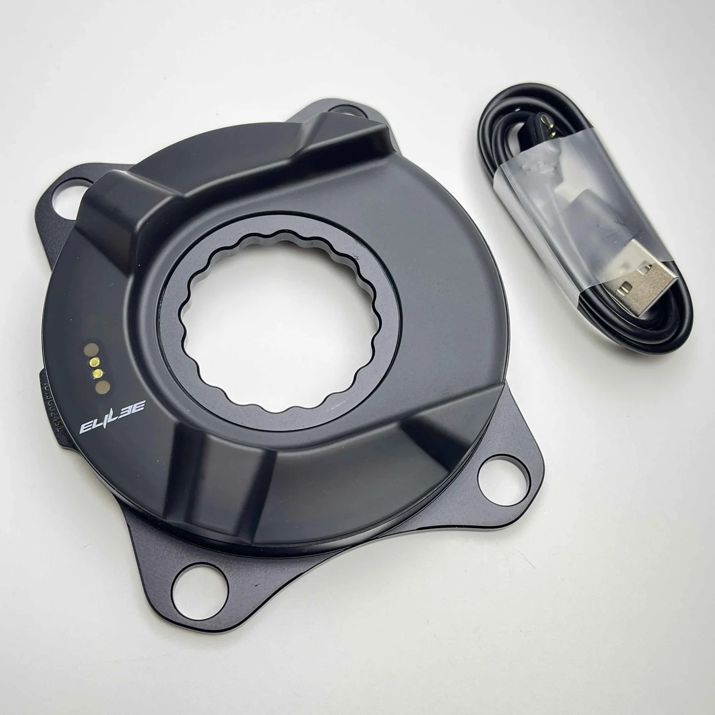 Elilee EK01 carbon version with cover removed and the included magnetic USB charging cable — shows the contactless charging pogo pads on the spider body