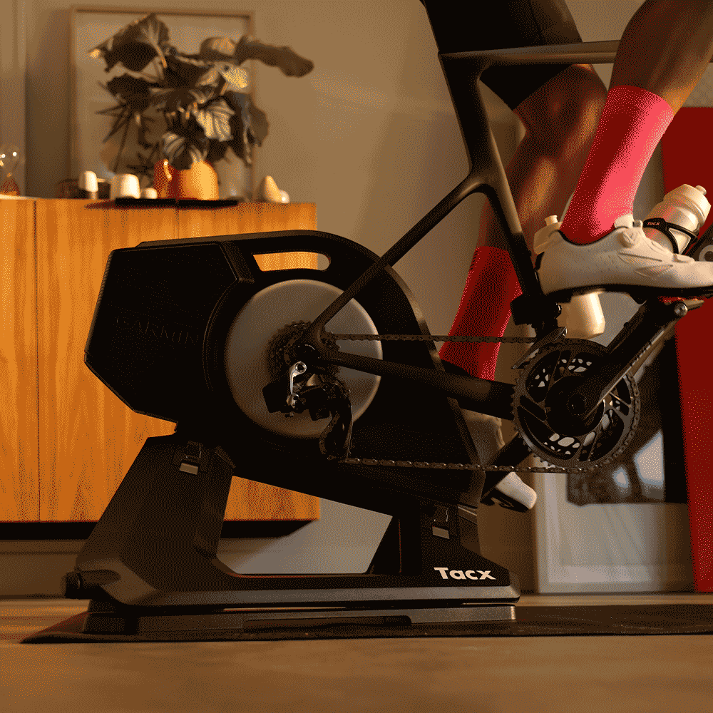 Garmin Tacx NEO 3M — installed under a bike, showing chassis, integrated motion plates, and the carry handle