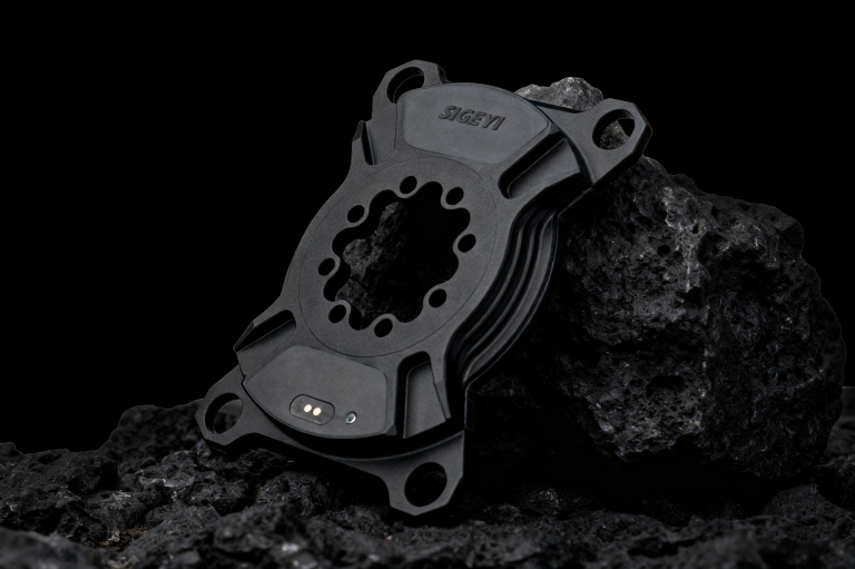 SIGEYI AXO SL spider unit on dark rock — strain gauges and charging contacts visible